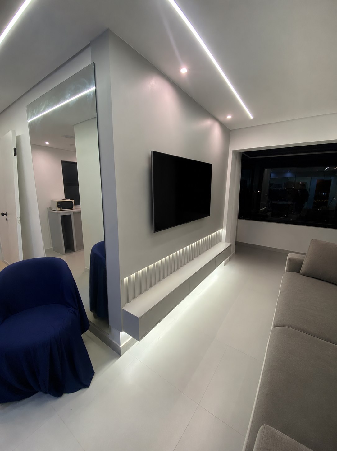 Sala de estar planejada com painel de TV iluminado